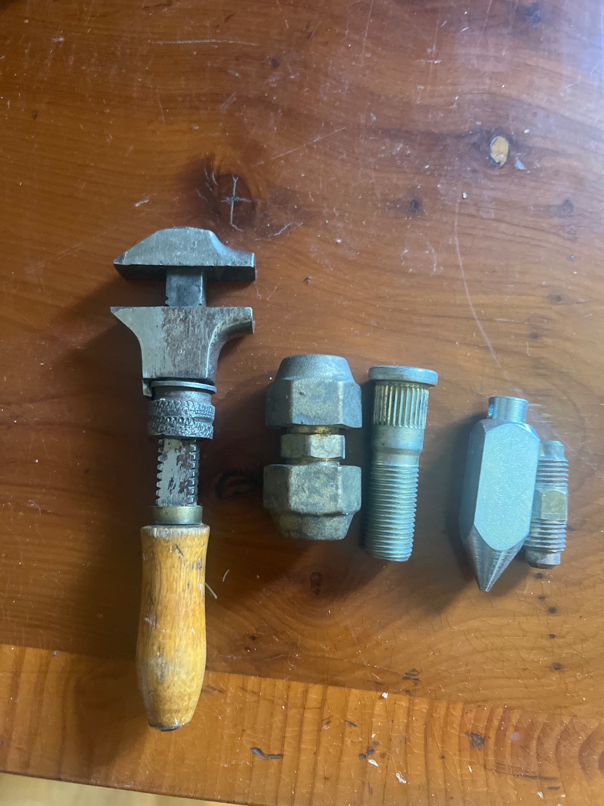 Gammal skiftnyckel och diverse metalldelar